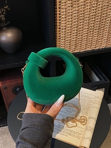 Emerald green velvet crescent handbag with golden chain strap and round top handle