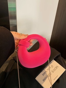 Hot pink artistic hollow handbag with gold chain strap in modern minimalist style