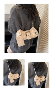 Detail of beige crescent bag featuring metallic buckle, pleats and coin purse attachment