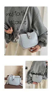 Detail of light blue saddle bag featuring brown contrast edges and heart charms