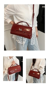 Detail of dark red glossy leather handbag with silver metallic buckle and shoulder strap