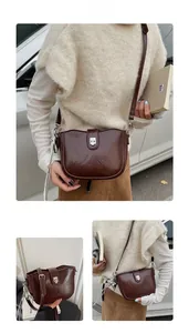 Detailed close-up of dark brown vintage saddle bag featuring silver clasp and leather texture