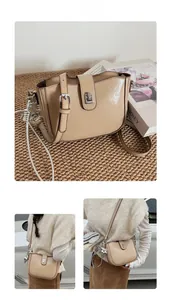 Detail of khaki faux leather shoulder bag with glossy texture and star charm