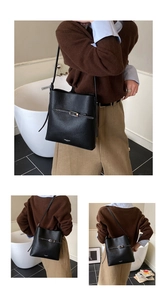 Détail d'un sac seau en cuir grainé noir avec boucle métallique et logo de marque