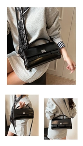 Detail of black glossy leather flap bag featuring a silver twist-lock and slim strap