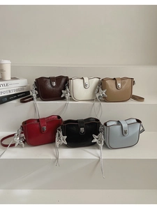 Row of colorful leather crossbody bags with silver star charms on white stairs
