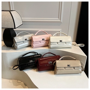 Row of six shiny patent leather flap handbags in silver, pink, beige, black, burgundy, and khaki