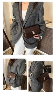 Detail of dark brown leather crossbody bag with gold oval clasp and double straps