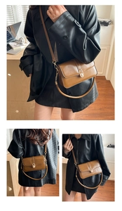 Detail of caramel brown leather shoulder bag with gold oval buckle and flap design