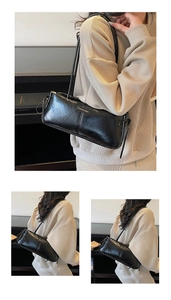 Close-up of black glossy leather Boston bag with metallic logo and stitching details