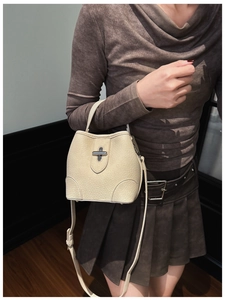 Detailed macro of cream lychee texture bucket bag with silver twist lock and leather strap