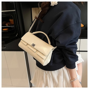 Detailed view of the square metal clasp and premium leather texture on a beige baguette bag