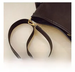 Dettaglio della tracolla in pelle regolabile con fibbia in metallo dorato dallo stile vintage