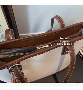 Detail of smooth gold zipper and stitching on the contrast color tote bag