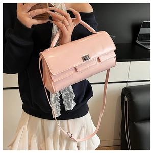 Close-up of pink patent leather handbag with silver twist lock in a home office setting