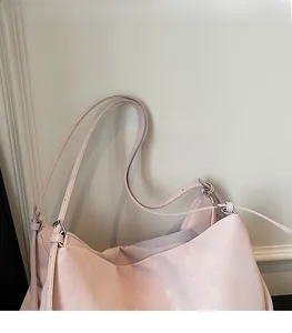 Detail of adjustable shoulder straps with silver metal buckles on a pink tote bag