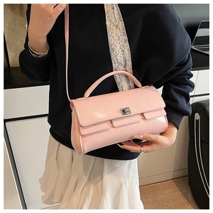 Detail of pink faux leather handbag with silver twist lock and round top handle