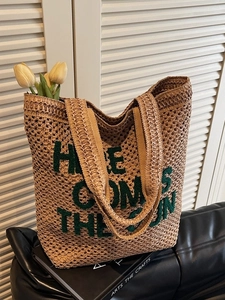 Woven straw tote bag with green Here Comes The Sun embroidery for summer vacation