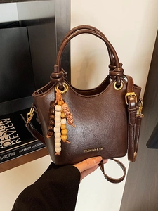 Dark brown retro oil wax leather bucket bag with beaded charm and gold logo detail