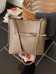 Sac seau en cuir grainé marron avec boucle en métal argenté dans un décor de style de vie chic