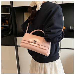 Close-up of pink patent leather handbag with metal turn-lock and thick top handle