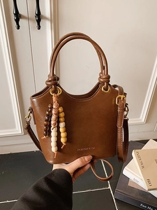Brown vintage leather bucket bag with wooden bead tassel and adjustable shoulder strap