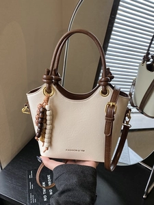 Stylish beige and brown bucket bag with ring handle and beaded tassel charm