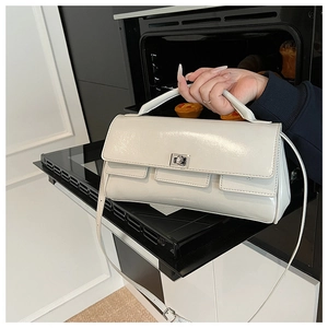 Detail of white glossy patent leather handbag with silver twist-lock and thick handle