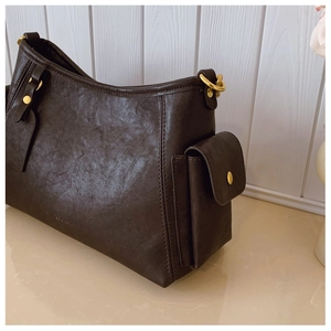 Dettaglio borsa a tracolla vintage in ecopelle marrone scuro con tasca e finiture dorate