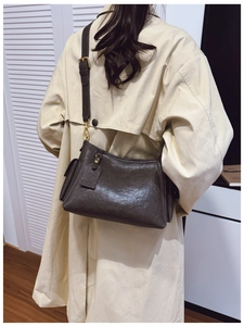 Dettaglio borsa in pelle marrone vintage con ganci dorati e tracolla regolabile