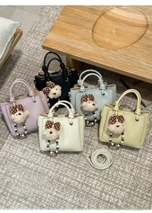 Dettaglio di borse in pelle martellata in cinque colori con ciondoli a forma di orso