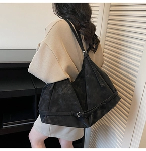 Detail of vintage black tote bag with textured material and silver buckle accents