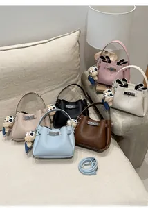 Detail of lychee pattern bucket bags in six colors with bear charms and straps