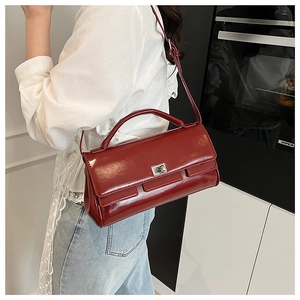 Burgundy flap handbag with silver rotating lock shown on model in casual lifestyle setting