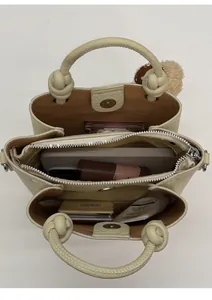 Vista interna della borsa beige con tre scomparti per contenere gli oggetti quotidiani