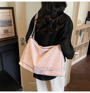 Close-up of soft pink matte faux leather tote bag showing buckle detail and supple texture
