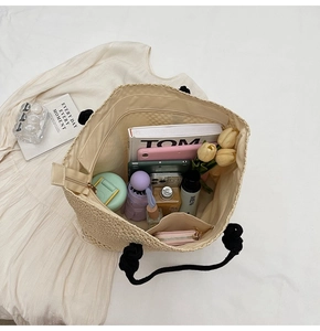 Detail of beige woven tote bag interior showing large capacity and zipper pocket