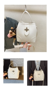 Detail of white lychee leather bucket bag with silver twist lock and cute dog charm
