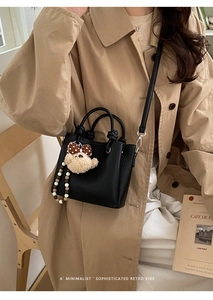 Dettaglio mini borsa a secchiello in pelle martellata nera con ciondolo orsetto