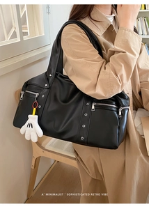 Detail of vintage black PU leather travel bag featuring silver studs and multiple zippers