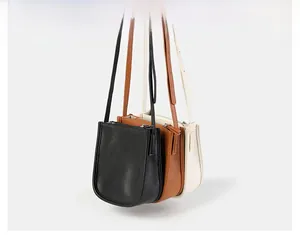 Detailansicht der Eimertaschen in Schwarz, Braun und Off-White mit Litschi-Lederstruktur
