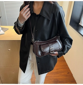 Detail of vintage dark brown faux leather underarm bag with Y2K buckle and pocket