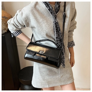 Detail of glossy black patent leather flap bag with silver rotating metal lock clasp