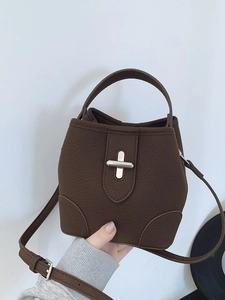Dark brown leather bucket bag with silver cross lock and adjustable shoulder strap