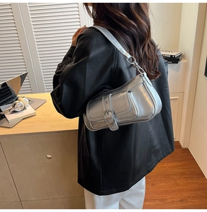 Silver metallic shoulder bag with metal buckle and chain strap worn by a female model