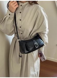 Detail view of a black PU leather underarm bag with silver buckle and smooth zipper