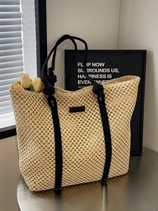 Minimalist beige woven straw tote bag with black rope handles and mesh hollow design