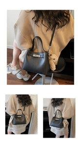 Detail of black pebbled leather bucket bag with silver twist lock and rabbit charm