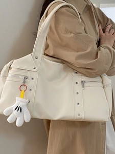 Cream white vintage oversized shoulder travel bag with silver studs and a plush charm