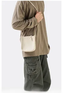 Detail einer minimalistischen cremeweißen Leder-Umhängetasche im lässigen Streetstyle